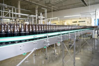Conveyor belt of brown bottles in a manufacturing facility